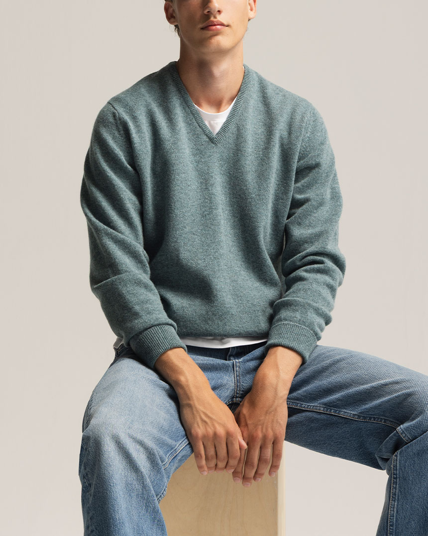 Pull vert à col en V avec jeans bleu